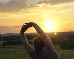 Eine Frau macht Sport bei aufgehender Sonne.