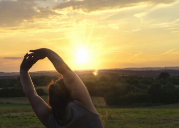 Eine Frau macht Sport bei aufgehender Sonne.