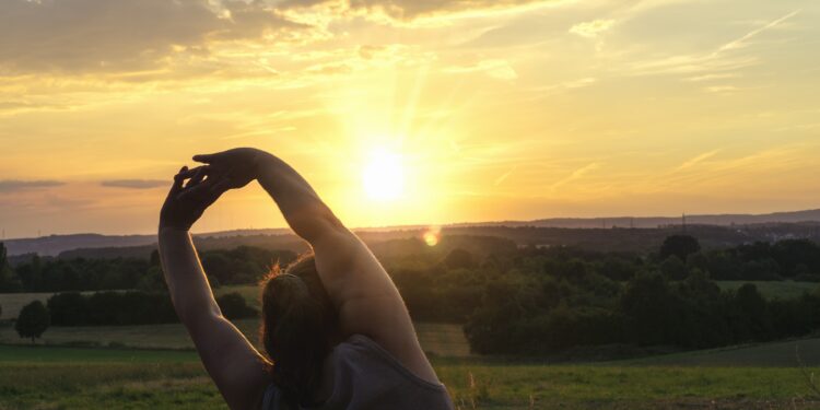 Eine Frau macht Sport bei aufgehender Sonne.