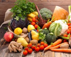 Eine Auswahl an frischem Gemüse und Obst auf einem Holztisch