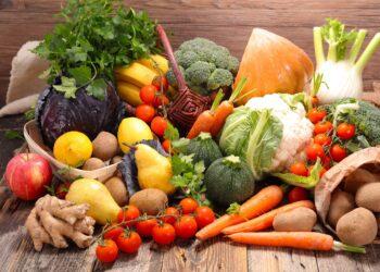 Eine Auswahl an frischem Gemüse und Obst auf einem Holztisch