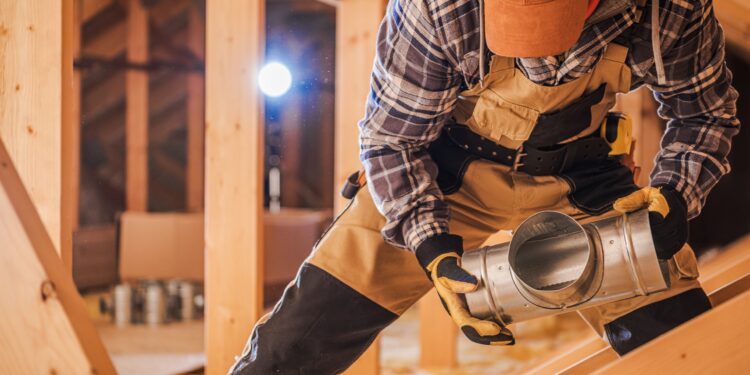 Ein Handwerker beim Bau einer Lüftungsanlage.