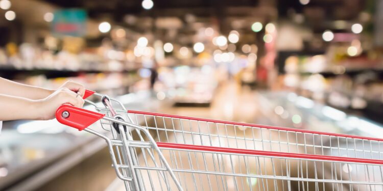 Frau schiebt Einkaufswagen im Supermarkt