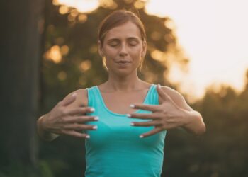 Junge Frau praktiziert Yoga im Freien.