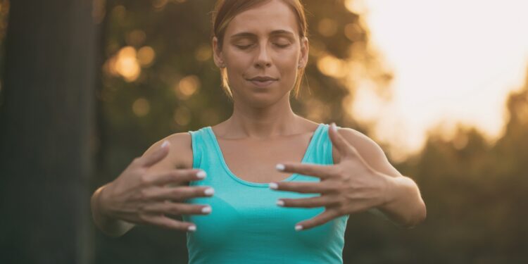 Junge Frau praktiziert Yoga im Freien.