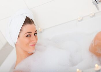 Eine Frau in der sitzt in der Badewanne mit viel Schaum