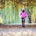 Eine Frau betreibt Nordic Walking in einer herbstlichen Landschaft.