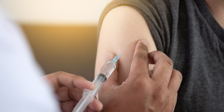 Arzt verabreicht einem Patienten eine Impfung in den Oberarm