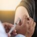 Arzt verabreicht einem Patienten eine Impfung in den Oberarm