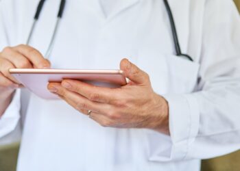 Artz überprüft auf dem Tablet in die elektronische Patientenakte.