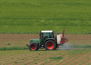 Traktor beim Versprühen von Pflanzenschutzmitteln auf einem Acker