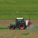 Traktor beim Versprühen von Pflanzenschutzmitteln auf einem Acker