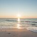 Strand am Meer mit Sonne am Horizont