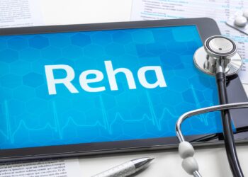 Stetoskop und Tablet mit dem Text Reha auf dem Display.