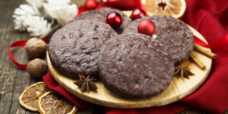 Lebkuchen auf einem Holzbrett mit weihnachtlichem Schmuck