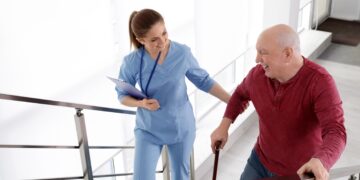 Eine Krankenschwester hilft einem älteren Mann beim Treppensteigen.