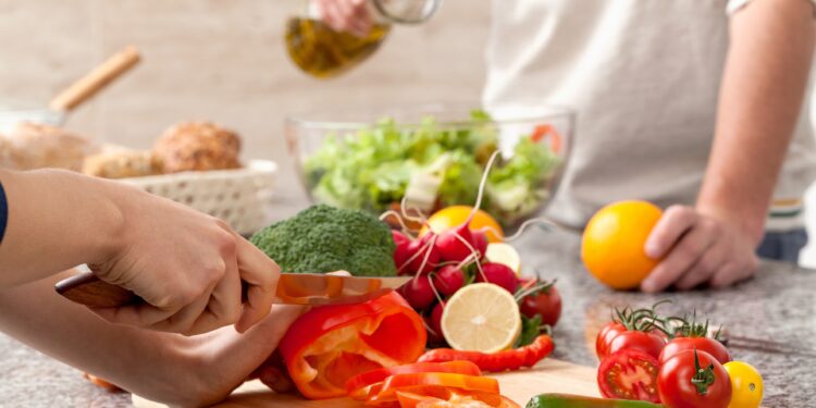 Paar bereitet zusammen einen Salat zu