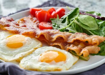 Low Carb Frühstück mit Eiern, Speck, Tomaten und Salat auf einem Teller