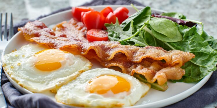 Low Carb Frühstück mit Eiern, Speck, Tomaten und Salat auf einem Teller