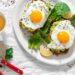 Gebratene Eier auf Brotscheiben mit Avocado neben einer Tasse Tee