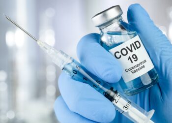 Spritze und Impfstoff für COVID-19.