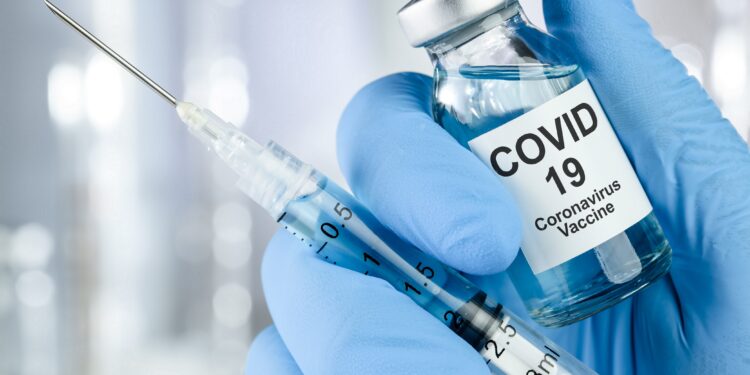Spritze und Impfstoff für COVID-19.