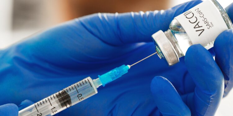 Hände in blauen Handschuhen bereiten Covid-19-Impfstoff für die Impfung vor