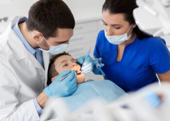 Zahnarzt untersucht Zähne eines Kindes