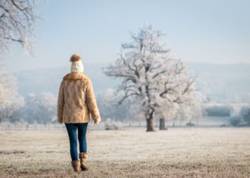 Frau macht einen Spaziergang in winterlicher Landschaft