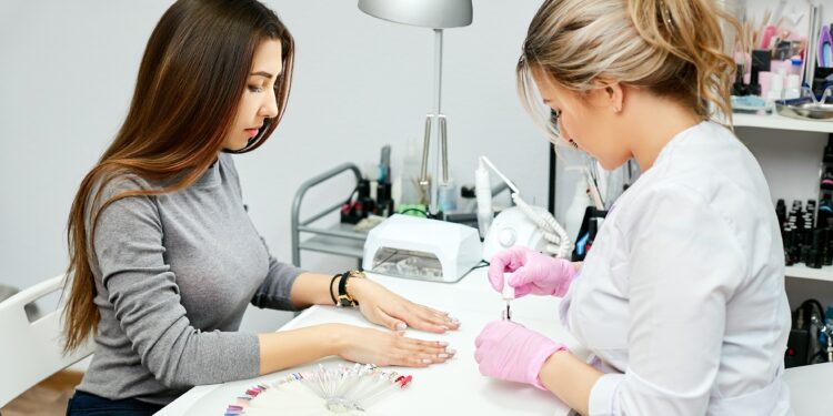 Frau lässt ihre Nägel in einem Nagelstudio machen.