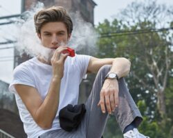 Jugendlicher raucht E-Zigarette.