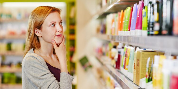 Eine Frau steht vor einem Supermarkt-Regal mit Pflegeprodukten.