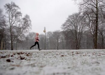 Eine Person joggt im Schnee.
