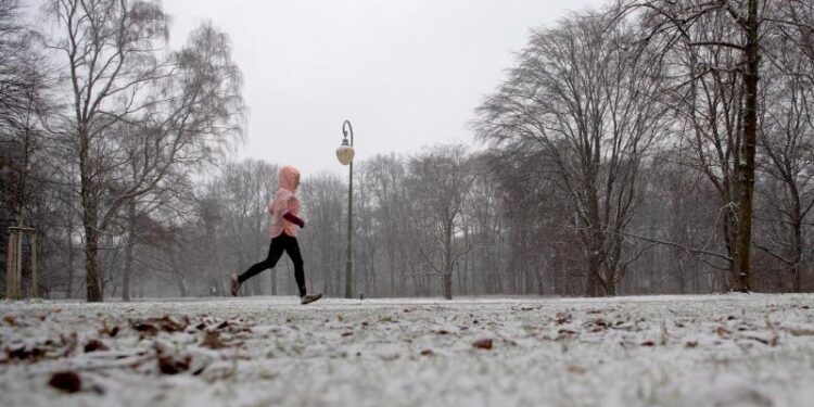 Eine Person joggt im Schnee.