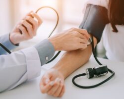 Arzt misst bei einer Patientin den Blutdruck