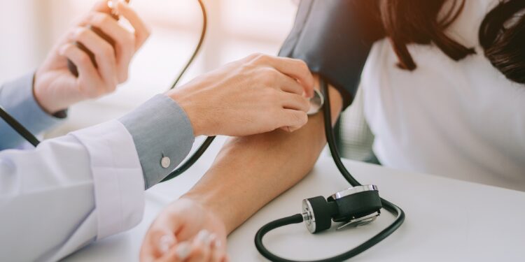Arzt misst bei einer Patientin den Blutdruck
