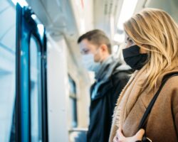 Eine Frau und ein Mann mit Mund-Nasen-Schutz in der U-Bahn