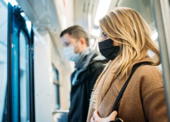 Eine Frau und ein Mann mit Mund-Nasen-Schutz in der U-Bahn