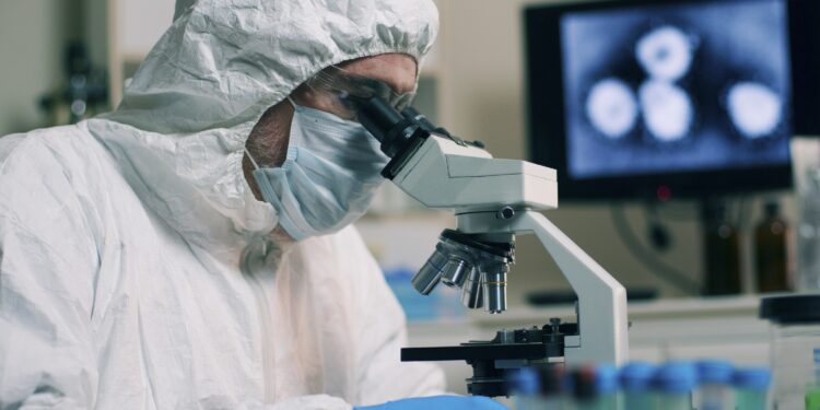 Forscher im Labor blickt in eine Mikroskop