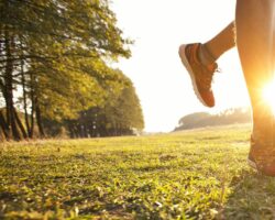 Junger Mann joggt querfeldein auf einer Wiese