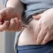 Übergewichtige Frau spritzt sich Insulin in den Bauch