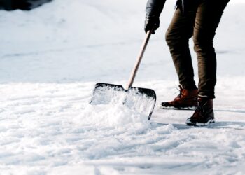 Mann beim Schneeschippen