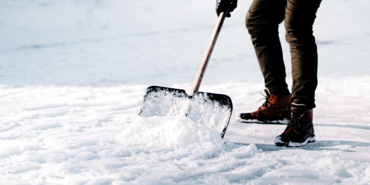 Mann beim Schneeschippen