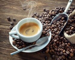 Bild von Kaffee in Tasse zusammen mit Kaffeebohnen.