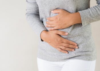 Junge Frau hält sich ihren schmerzenden Bauch