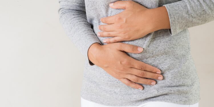 Junge Frau hält sich ihren schmerzenden Bauch