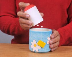Mann gibt Süßstoff in eine Tasse Tee