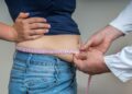 Arzt misst bei übergewichtiger Frau den Bauchumfang