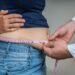Arzt misst bei übergewichtiger Frau den Bauchumfang