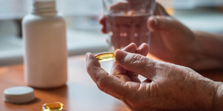 Ältere Frau nimmt Vitamin-D-Nahrungsergänzungsmittel ein